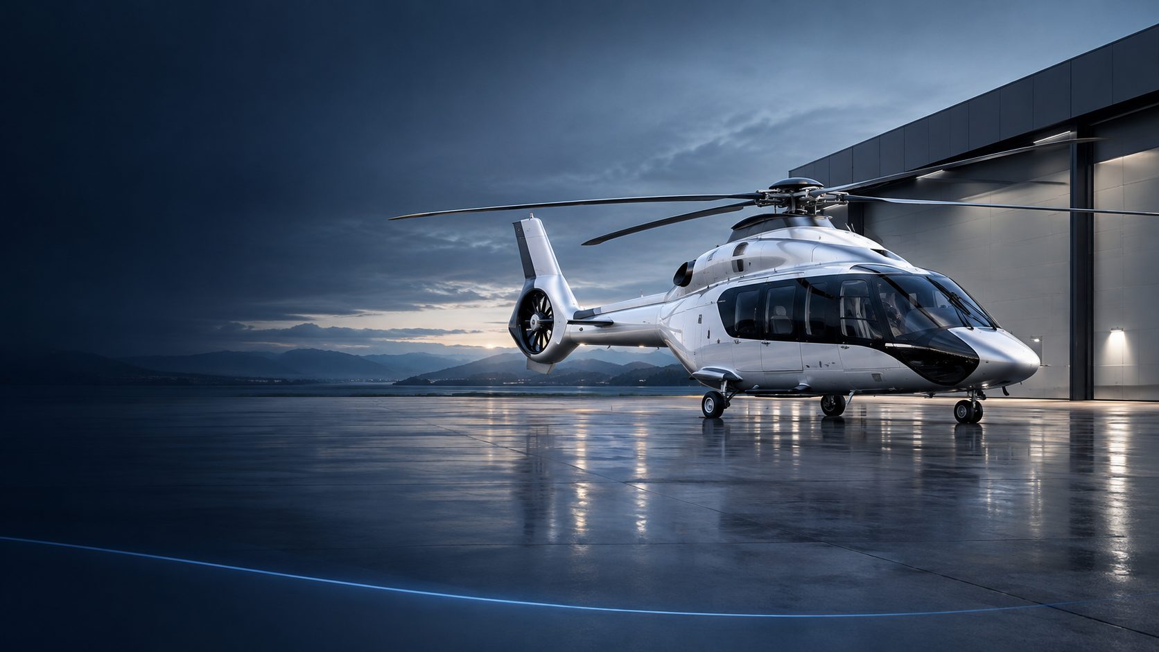 Twin-engine helicopter on a wet apron in front of a hangar